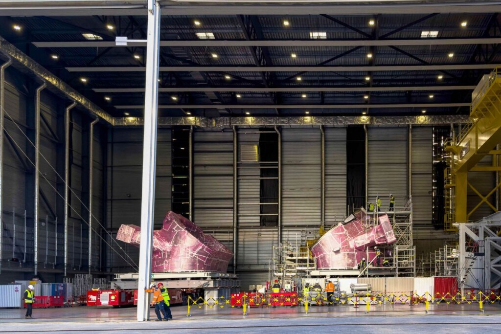 Les lourds battants de l’ancien Atelier cryostat s’écartent, laissant apparaître le module n°4 de la chambre à vide, positionné sur la gauche. Il peut enfin être extrait et conduit vers le Hall d’assemblage pour la suite des opérations.