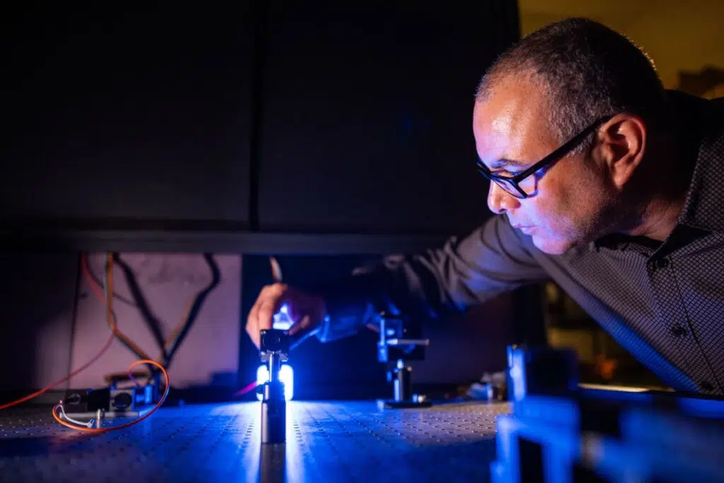Le physicien Israel Owens, de l'université Sandia, ajuste l'optique de son système de laboratoire. (Photo : Craig Fritz)