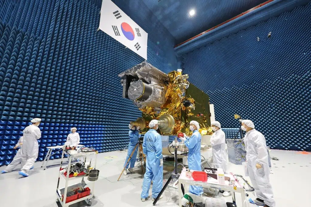 Essais électromagnétiques du satellite sud-coréen Chollian-2A au sein des installations du Korea Aerospace Research Institute (KARI) en août 2018. Cette phase de test visait à vérifier que les équipements électroniques du satellite pouvaient fonctionner sans interférences dans l’environnement extrême de l’espace. Avant même son lancement par Ariane 5, le futur observateur météo géostationnaire devait prouver qu’il pouvait résister à un véritable chaos invisible d’ondes et de rayonnements… un peu comme faire tourner un ordinateur ultra-sensible à l’intérieur d’un micro-ondes géant, sans le griller.
Crédit : Korea Aerospace Research Institute (KARI) — licence KOGL Type 1.