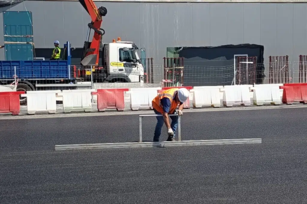 Un employé teste le niveau de planéité du circuit qui ne pardonne que 2 millimètres d'écart tous les trois mètres.