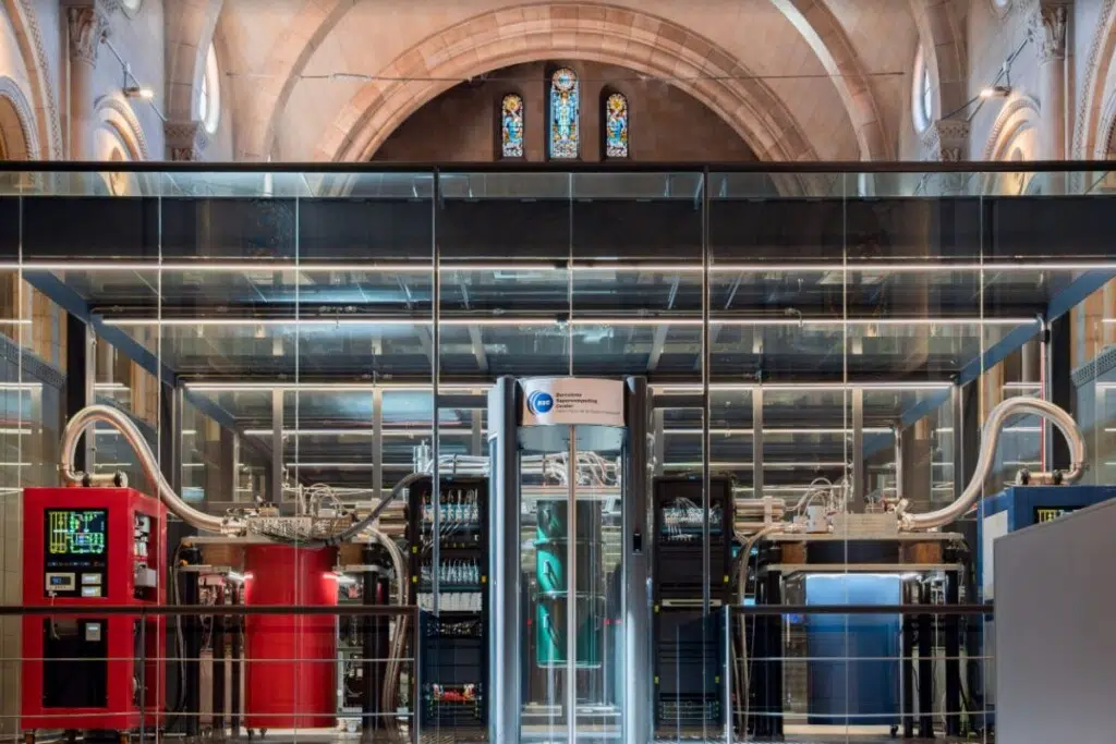 MareNostrum-Ona, la partition de calcul quantique de MareNostrum 5, est installée dans la chapelle Torre Girona du Centre de supercalcul de Barcelone. Les systèmes rouge et bleu sont les ordinateurs quantiques numériques ; le système vert au centre est le nouvel ordinateur quantique analogique inauguré. Crédit : BSC-CNS
